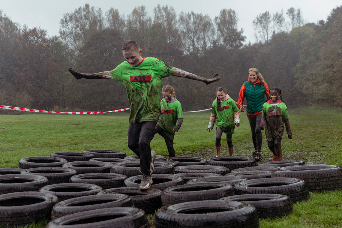 An image of two people jumping hurdles while both holding on to a hula hoop around them.