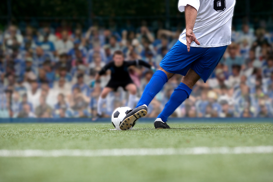 An athlete’s foot just as it hits a soccer ball