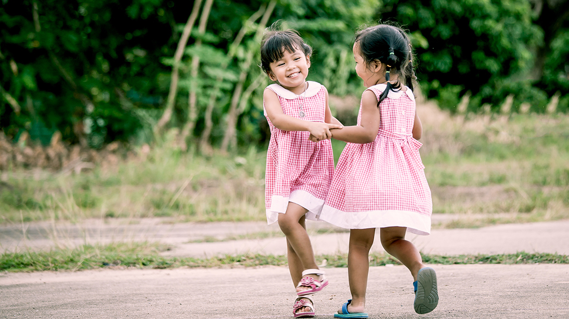 Two children dancing outside