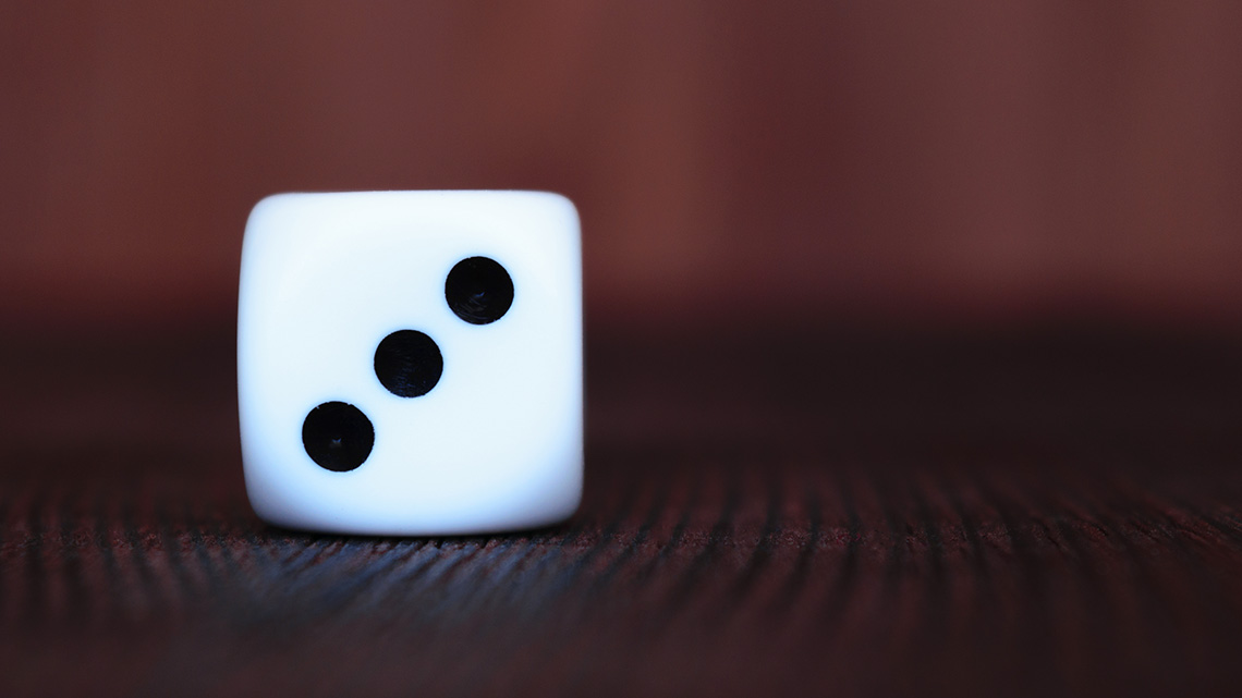 Three dots appear on the visible face of the die.