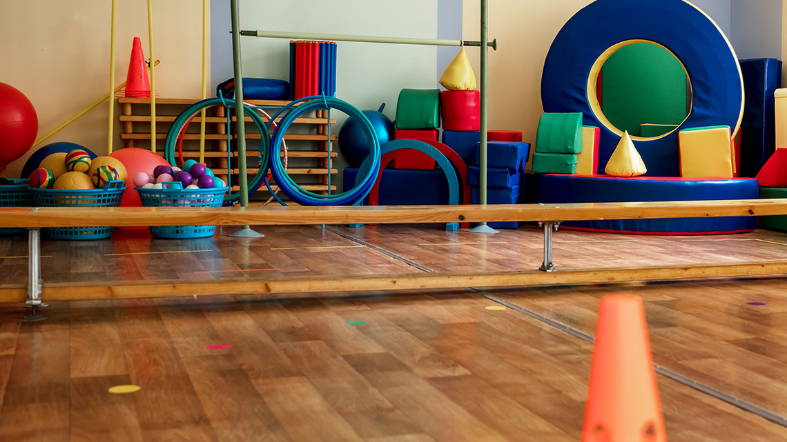 An indoor play space is shown with gym equipment and soft play items.