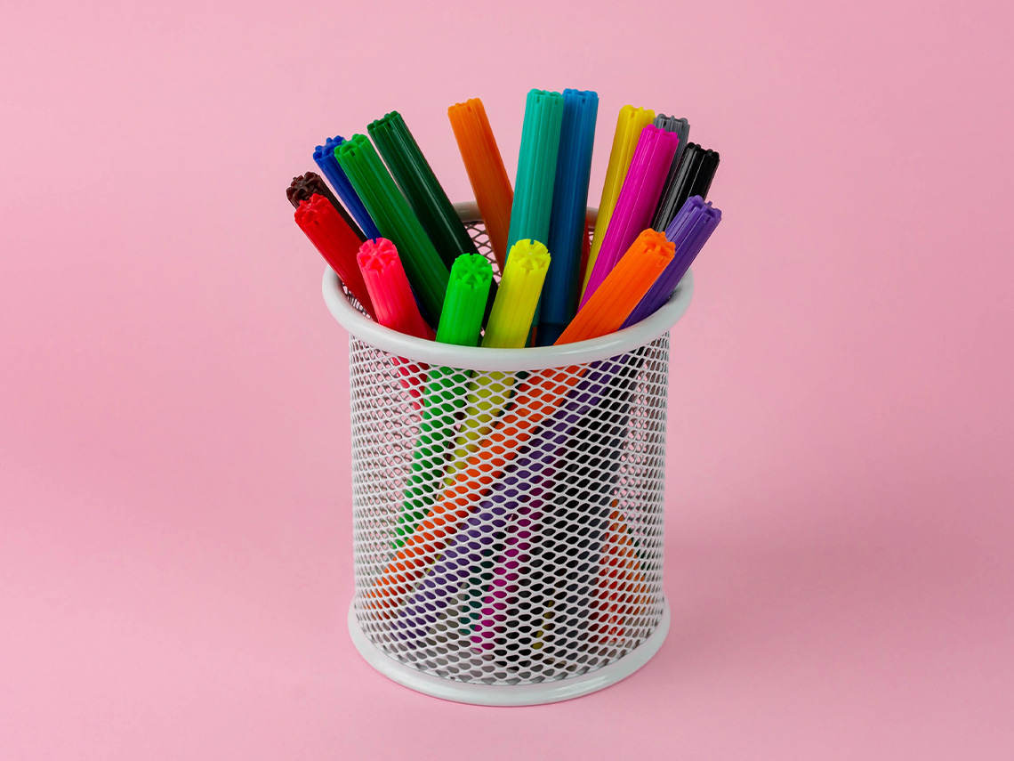 A container holding many colorful markers.