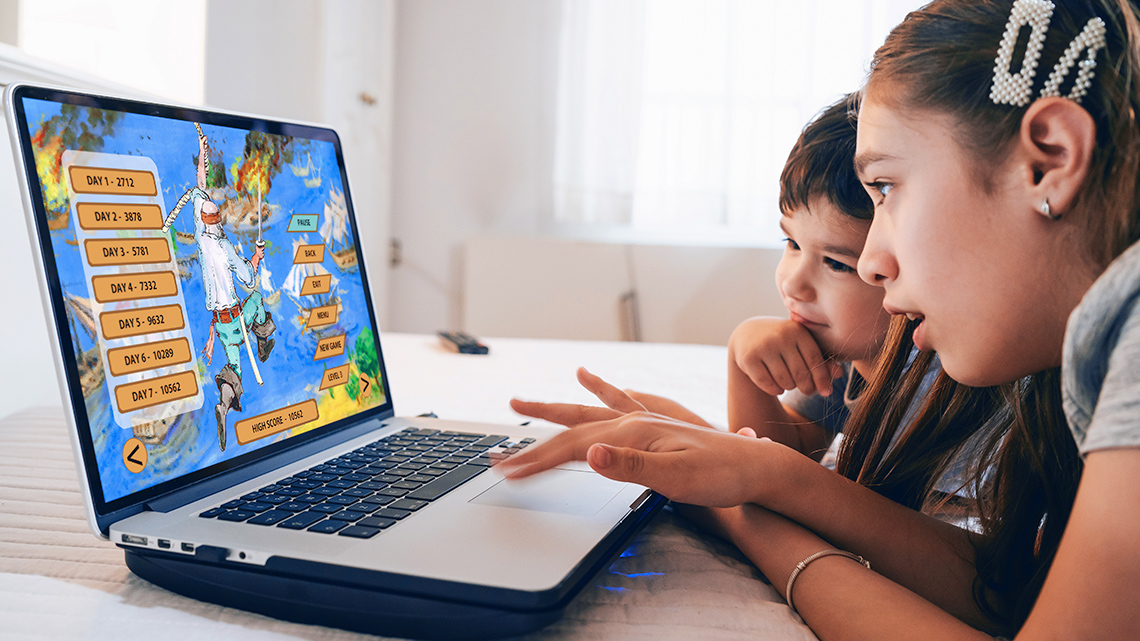 Two learners are looking at an online game on a computer screen.