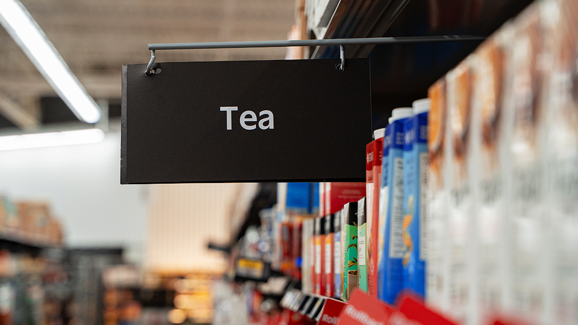 A sign in a grocery store aisle with the text, tea.