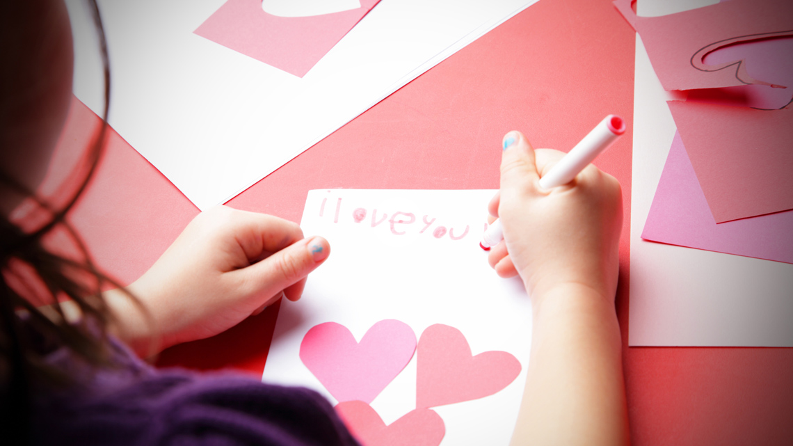 A learner writing on a greeting card.