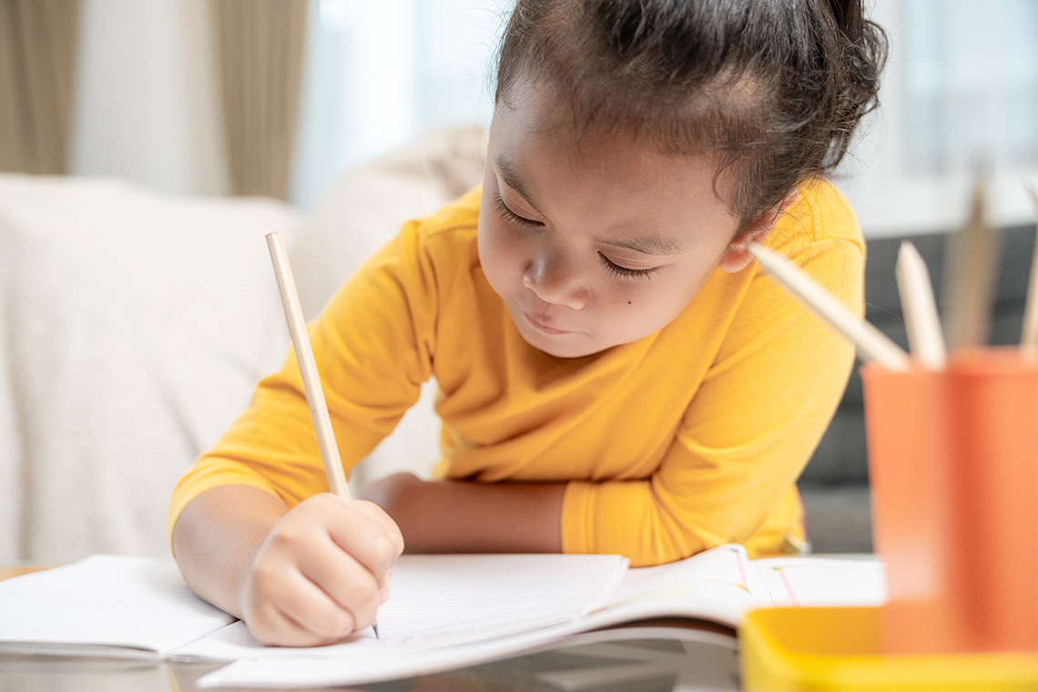 A young child writing on paper.