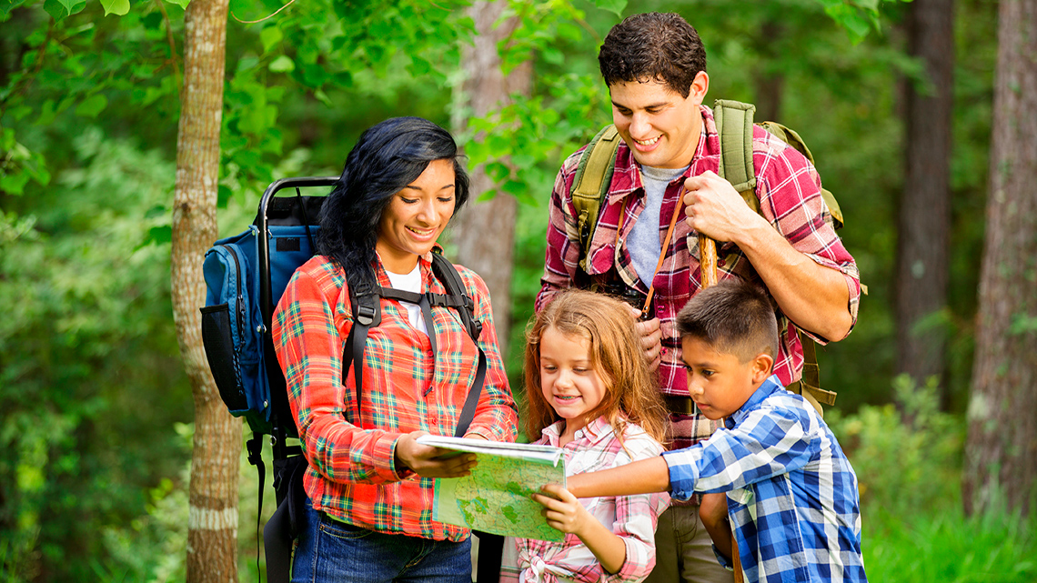 Two children explore a map with two adults.