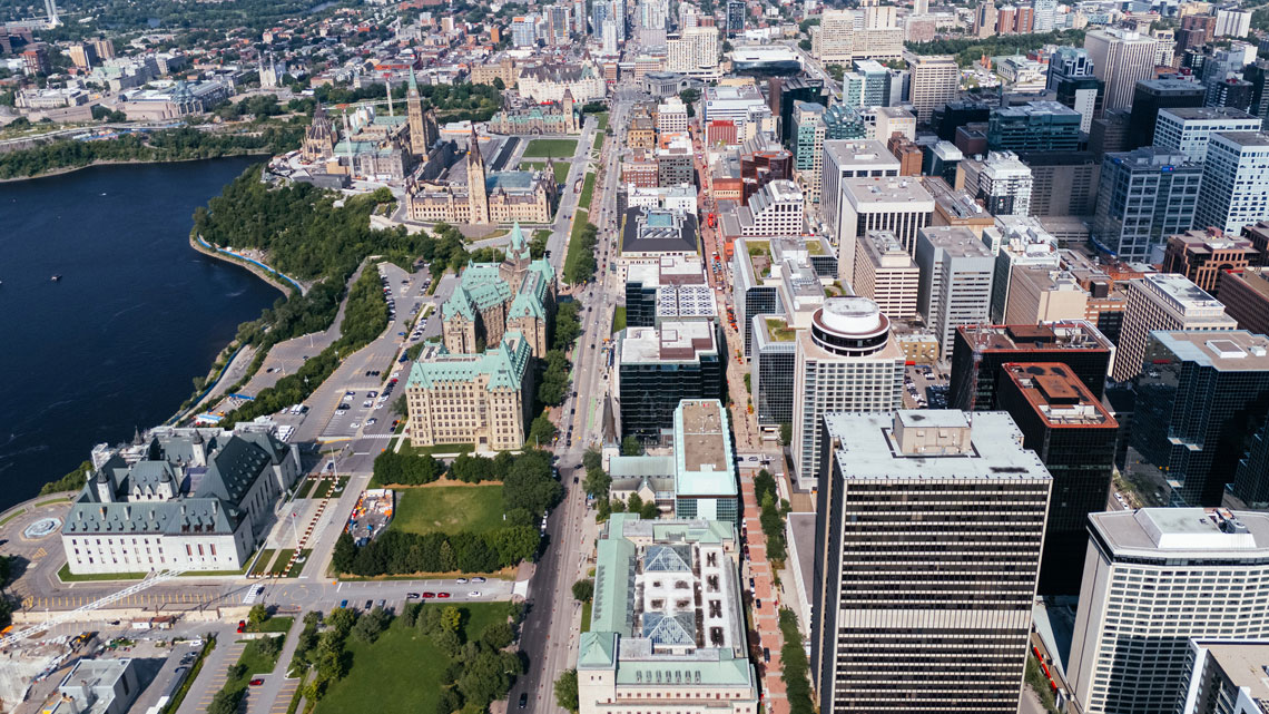 A city with many streets and tall buildings made of concrete, bricks, and glass.