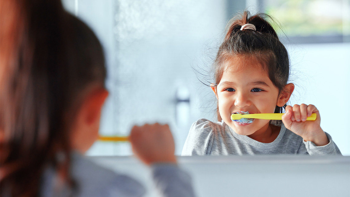 A kid brushing their teeth.