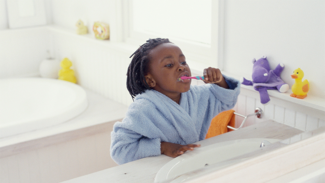 A kid brushing their teeth.