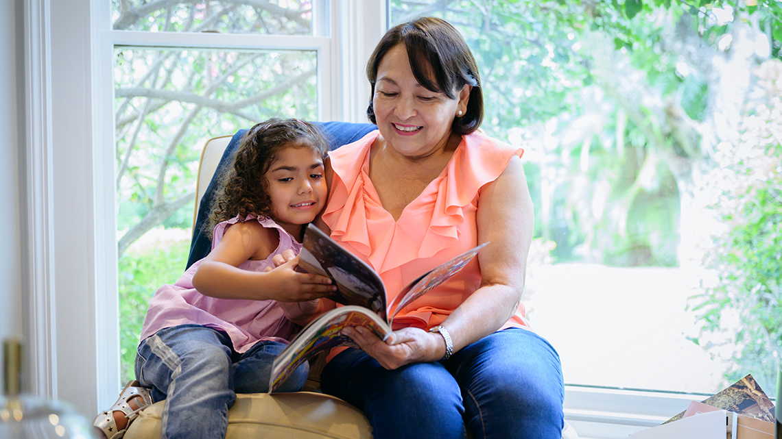 Mother and daughter looking through a magazine at home