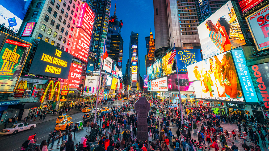 An image of a busy street withbillboards covering the buildings on both sides of the street.