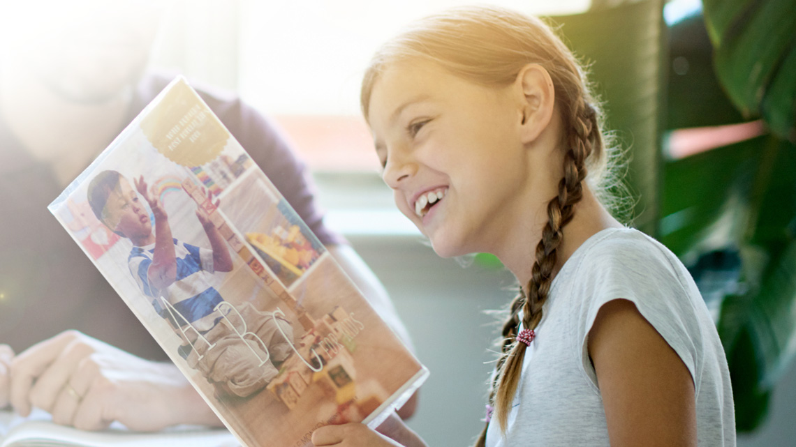 An image of a woman sitting and reading a brochure.