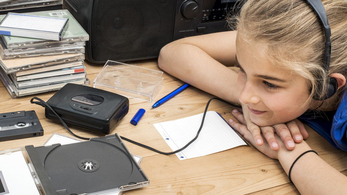 grade 7 kid looking through a pile of music CD/albums or magazines