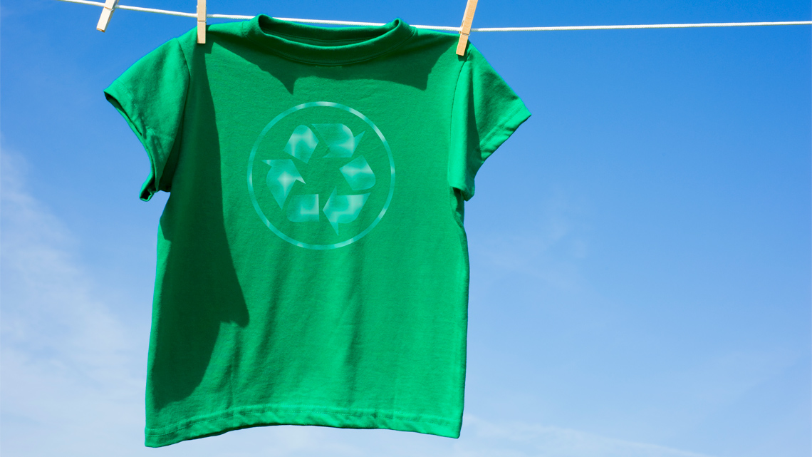 A sweater on a hanger with a tag that says made from 100% recycled wool.