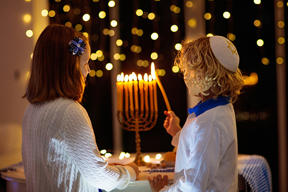 Celebrating Hanukkah by lighting candles on a menorah