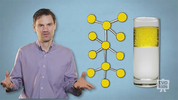 A still from Oil and Water. Damian has a serious expression and open arms to communicate a fact.