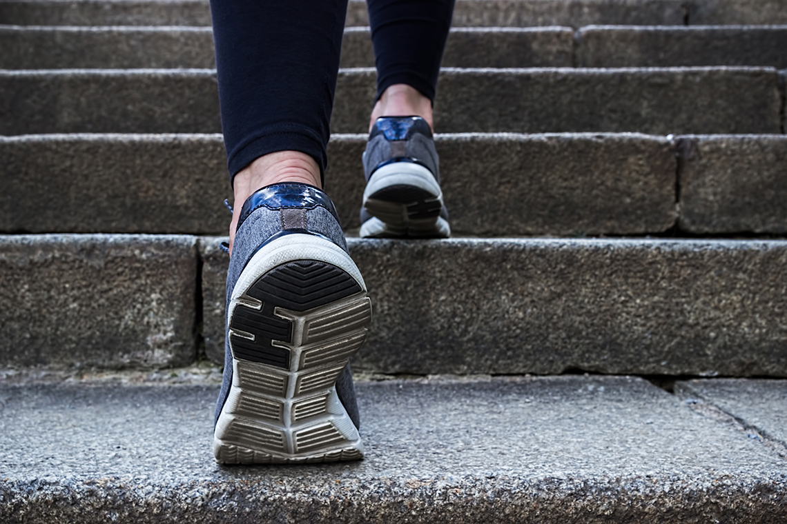 Steps Two feet in sneakers walking up stairs.