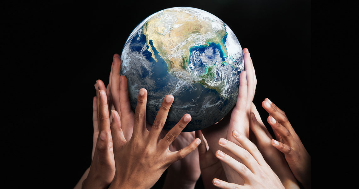 Many hands are holding the planet Earth.