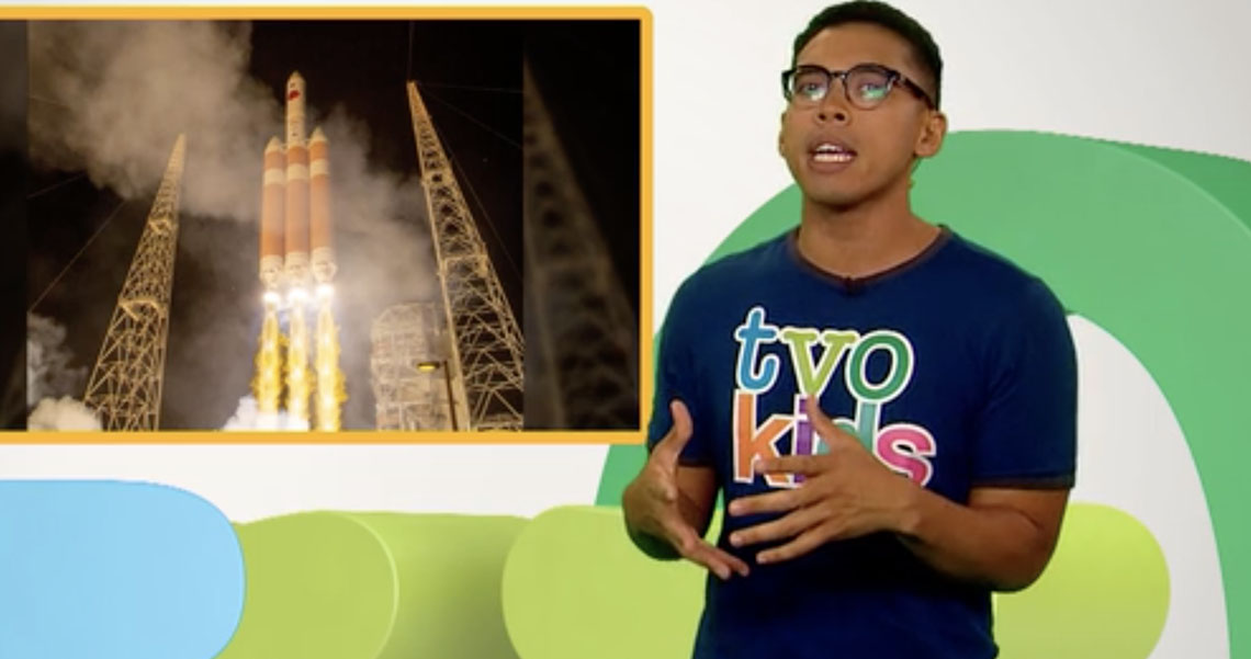 Daniel presents a photograph of a rocket taking off from Earth. 