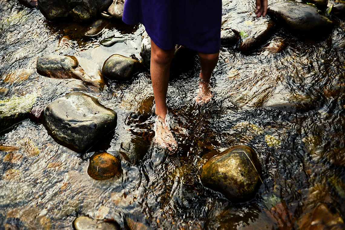 A person barefoot on the river.