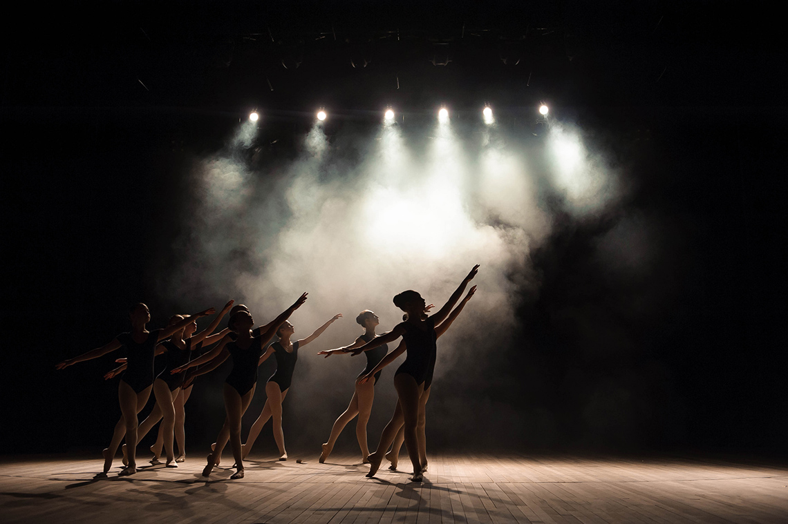 A group of students rehearsing for a play in an auditorium.