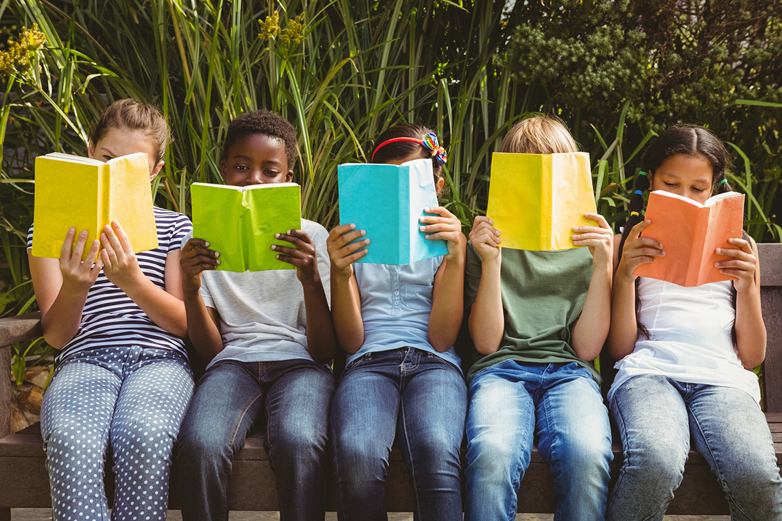 Three children read a book together