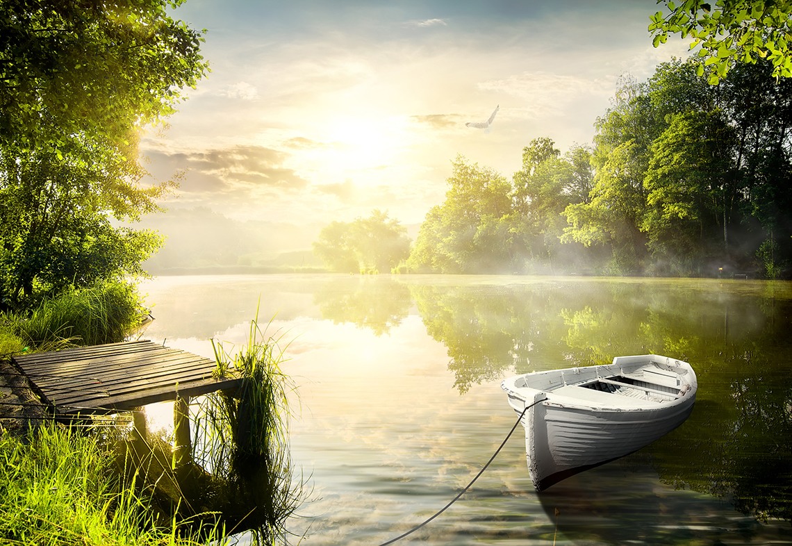 The image is of a river with a small amount of steam rising off the water. There are green trees surrounding the river.