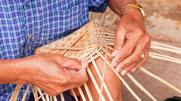 Hands weaving a basket