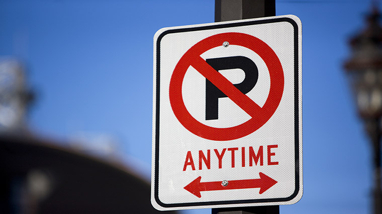 No parking road sign. A diagonal line cancelling across a red letter P.