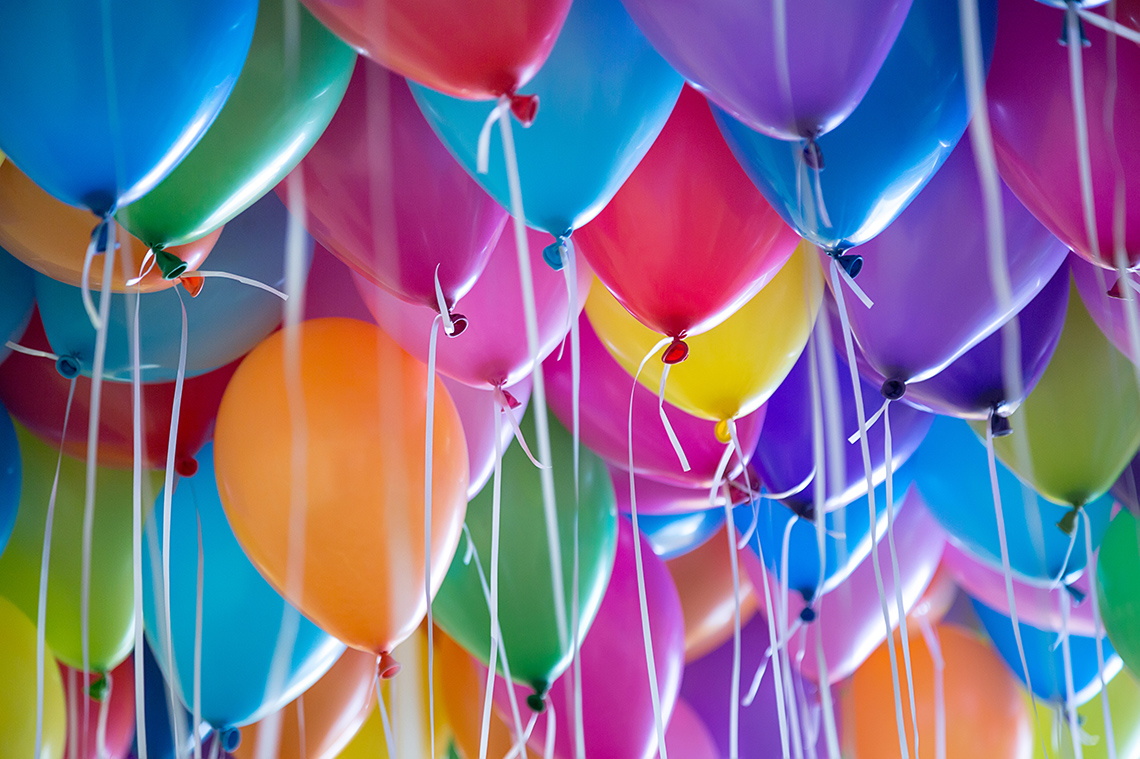 Colourful balloons with ribbons.