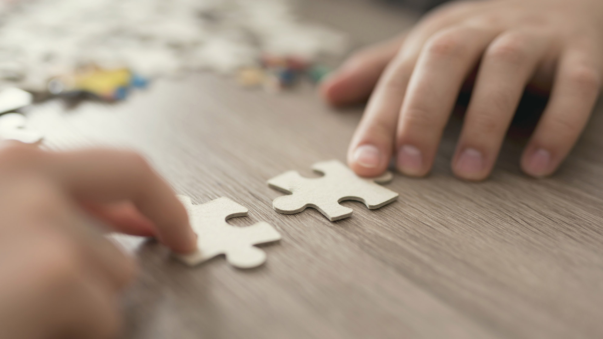 Two hands matching puzzle pieces.