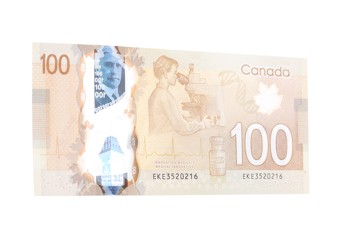 The back of a Canadian 100 dollar bill. The bill has the number 100 and a picture of a scientist.