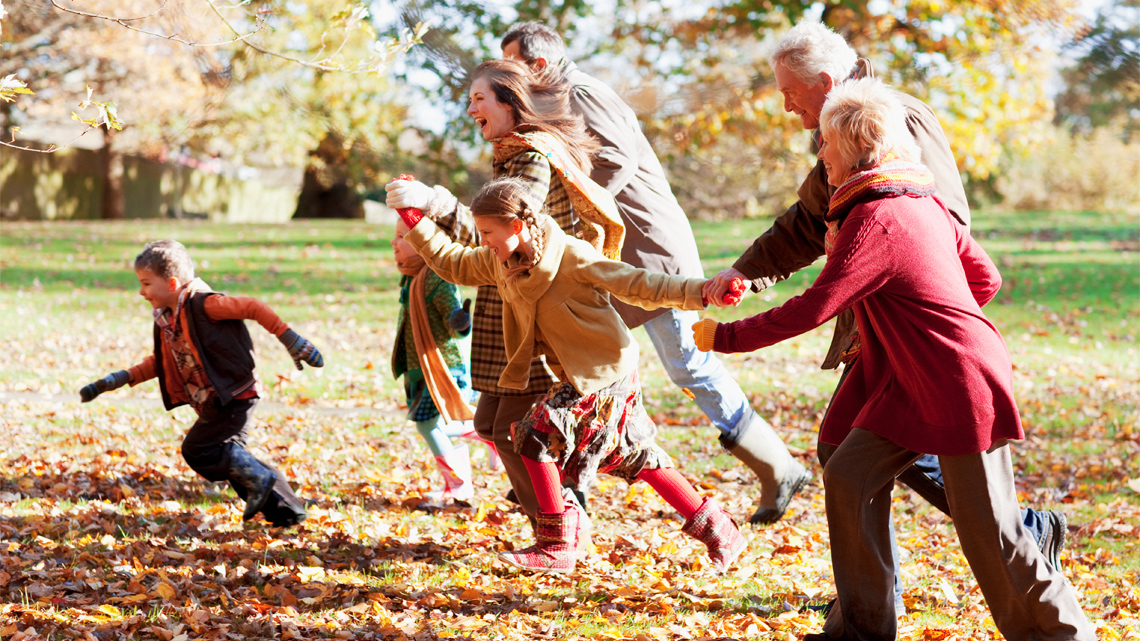 Seven family members enjoy on autumn day. Two grandparents are the focus.