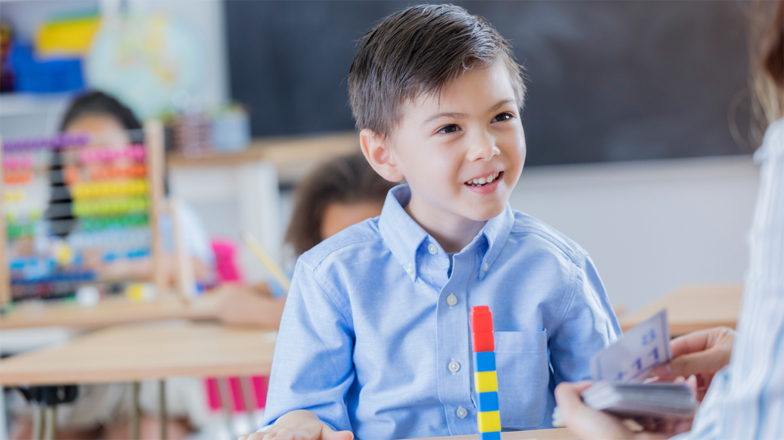  Two students stacking and measuring with snap cubes.