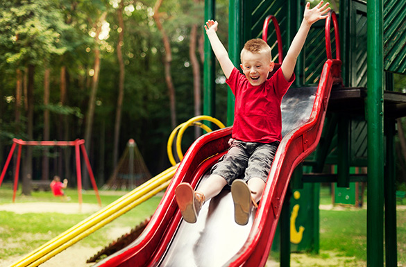 Child going down a slide at the playground.