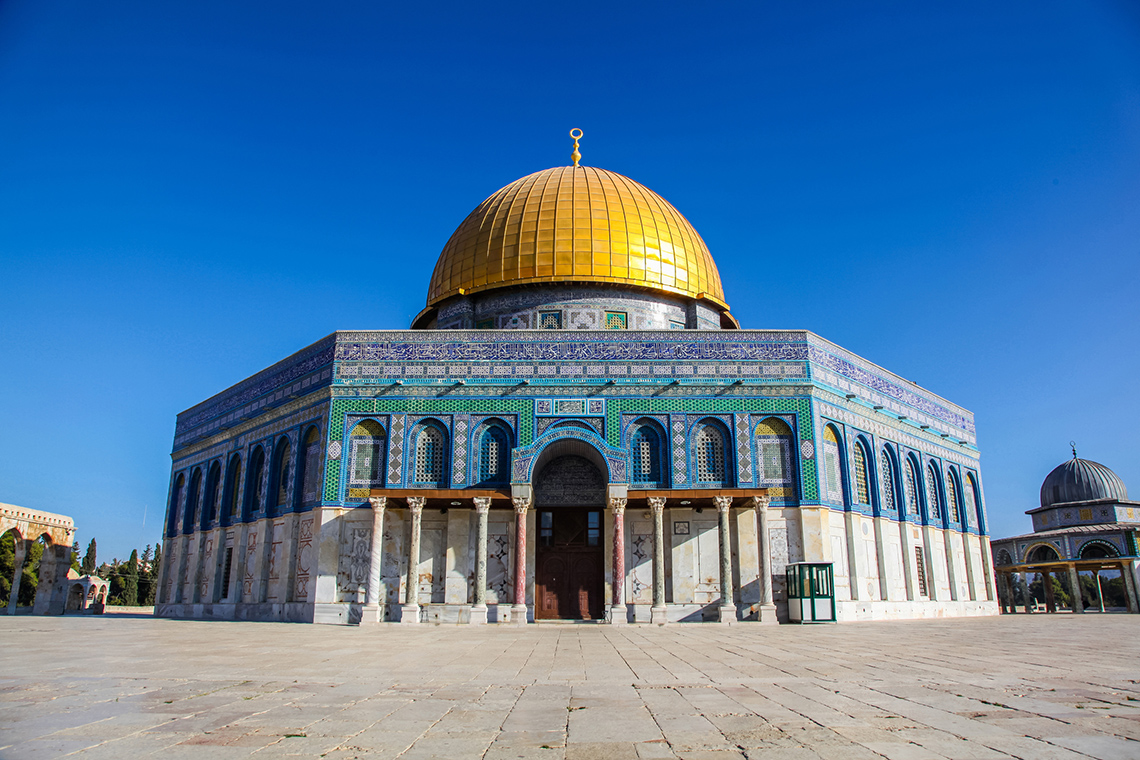 A mosque. The building has a hexagon base with a cylinder tower.
