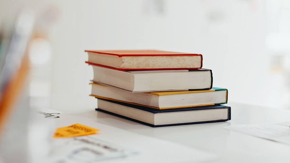 Stack of four rectangular books on top of each other.
