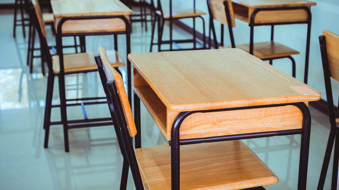 Rows of school desks and chairs.