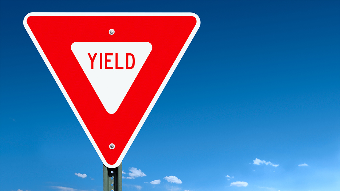 A triangular shaped street sign with a yield symbol inside.