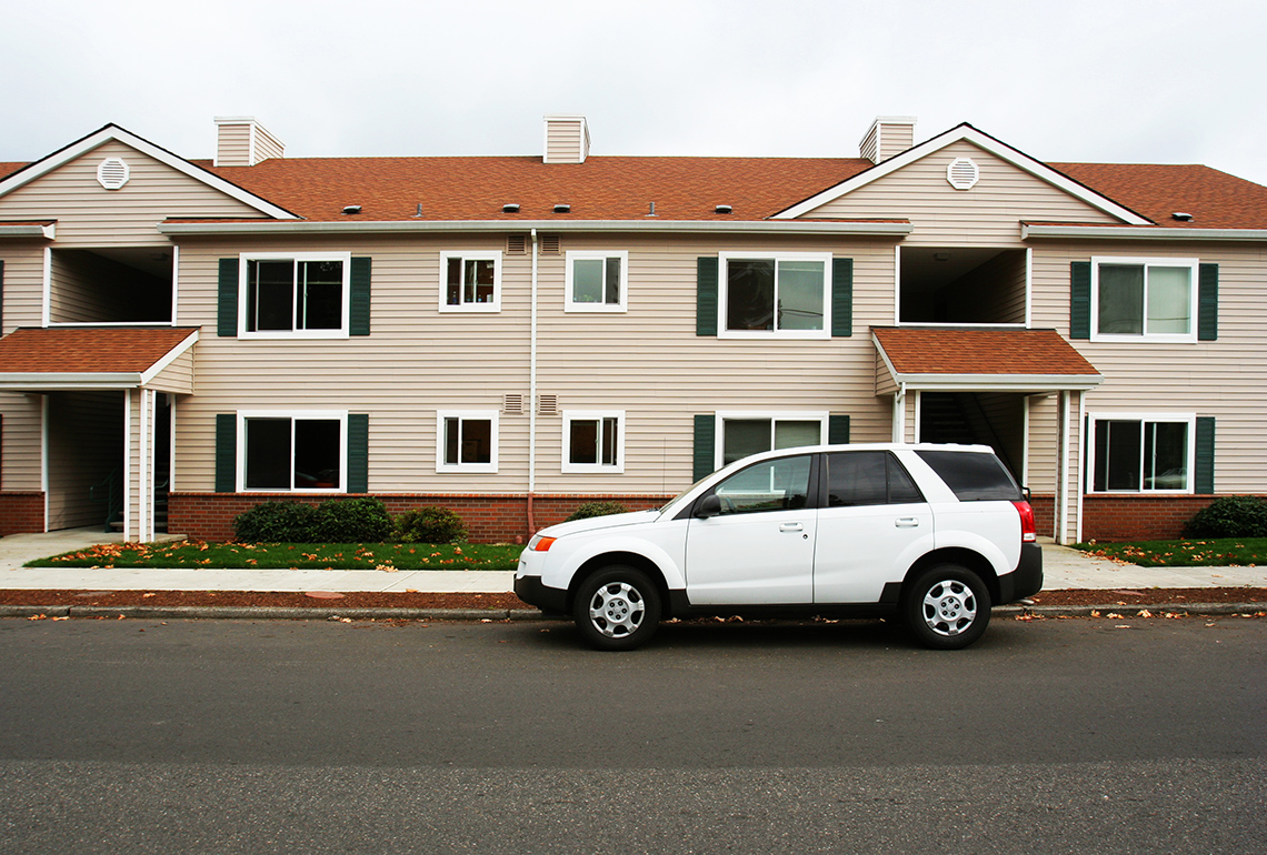 A line of cars parked outside a building.