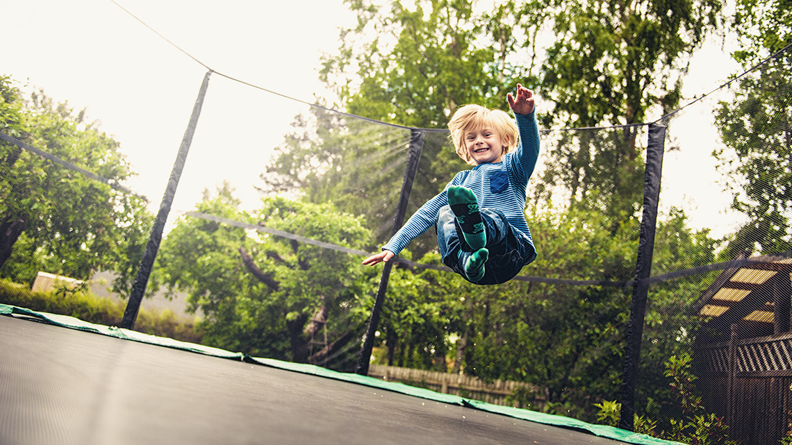 A child jumping on a trampoline.