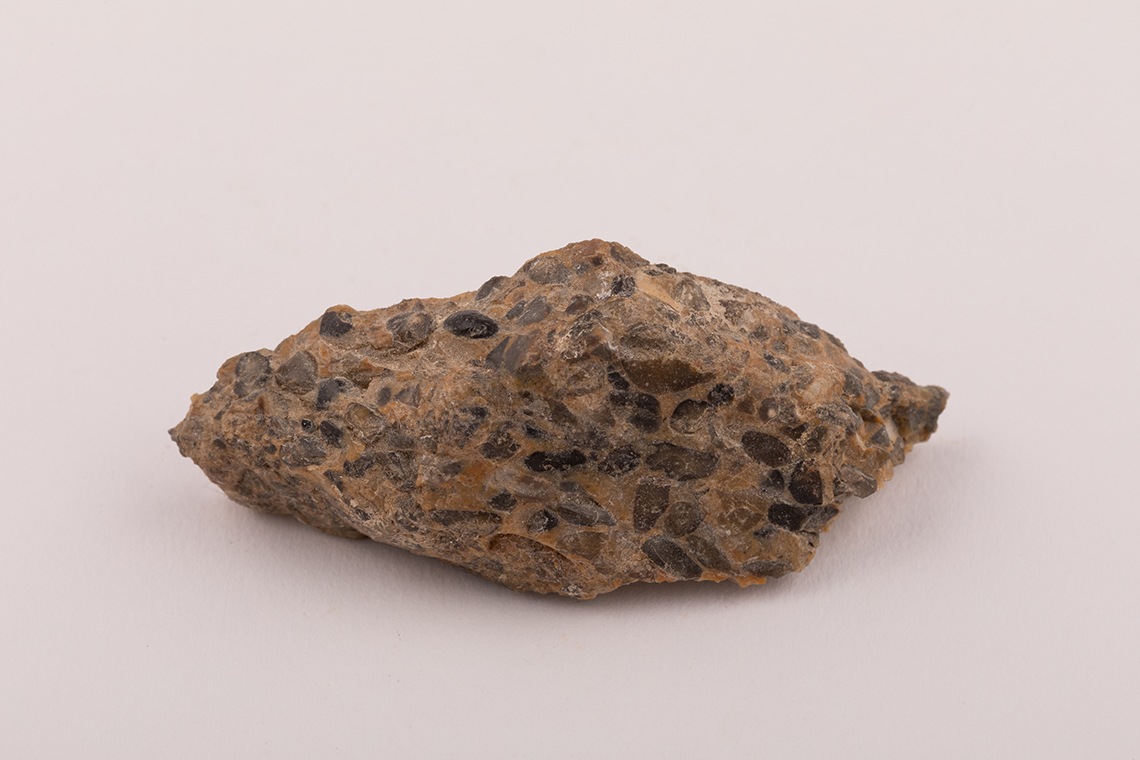 This is a rock made of different minerals. It includes rounded well sorted flint pebbles in a very fine quartz mix.