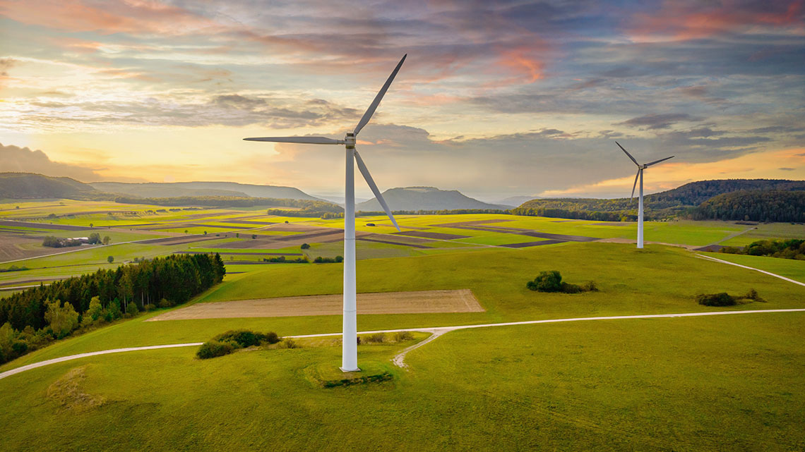 A single wind turbine is in a grassy field.