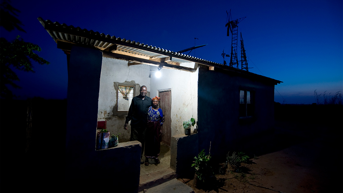 Two people standing outside of a house.