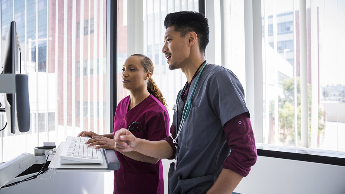 Two healthcare workers working at a computer.