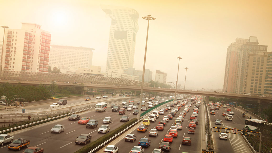 Rows of cars on a highway. The air is smoggy.