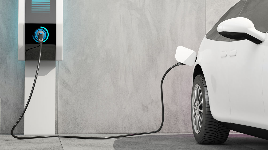 An electric car plugged in to charge at a charging station.