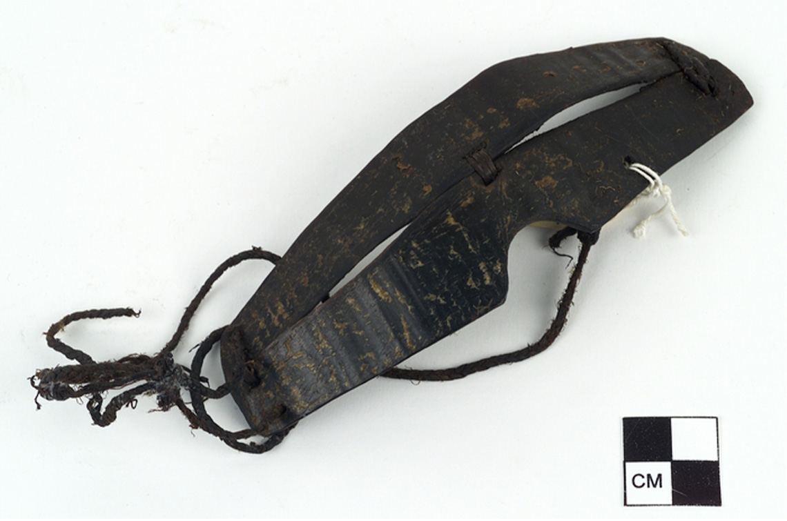 Snow goggles carved from baleen or whalebone and laced using sinew. Narrow slits are created on each side of the goggles.