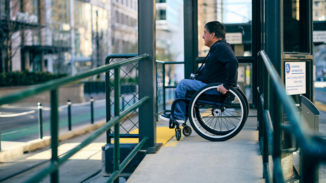 A person using a wheelchair waits for a street car at an accessible entrance.